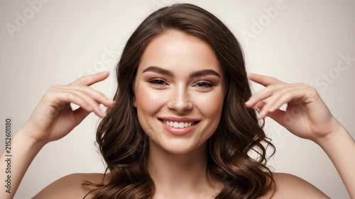 Beautiful Young Woman with Natural Makeup Smiling and Posing with Fingers on Temples.