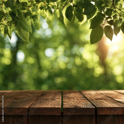 Wooden table foreground with sunlit green leaves and bokeh background