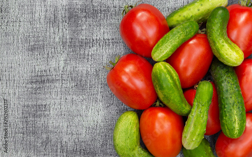 Fresh seasonal tomatoes and cucumbers on wood, suitable for vegetarian food concepts, recipe content, and retail retail.