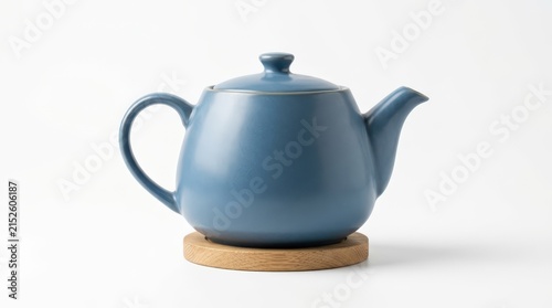 Minimalist blue ceramic teapot on wooden coaster, modern porcelain tea pot for kitchen decor, elegant stoneware kettle on white background