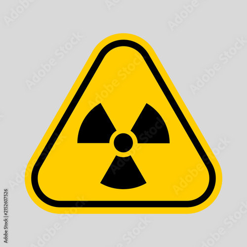 Obraz na plátne Yellow triangular warning sign with a black radiation symbol, indicating radioactive hazard and the need for safety precautions