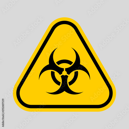 Fotografie Yellow triangular warning sign featuring a black biohazard symbol, indicating biological contamination or infectious material