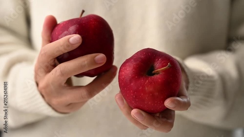 Close up of woman hands holding and selecting fresh red delicious apples, concept for healthy eating, organic food, and natural nutrition