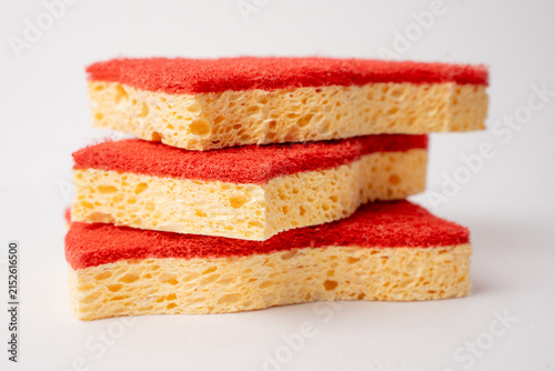 Stack of red and yellow kitchen sponges isolated on white background.