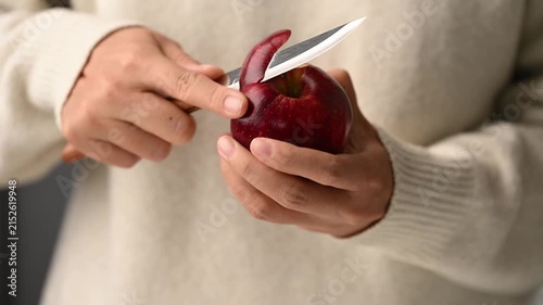 Close up of woman hands peeling a fresh red delicious apple with a paring knife, Healthy eating