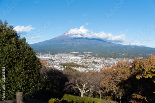 A scenic panoramic view of snow-capped Mount Fuji overlooking Fujinomiya city from Shirao Mountain Park (Shiraosan) on a sunny December afternoon. Horizontal shot.