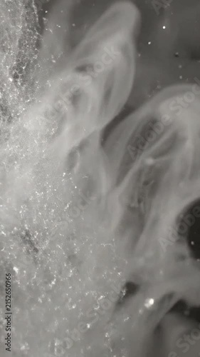 Abstract white ink swirling in dark liquid
