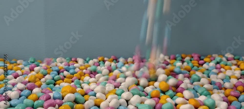 Colorful Small Spheres Falling into a Pile of Similar Spheres.