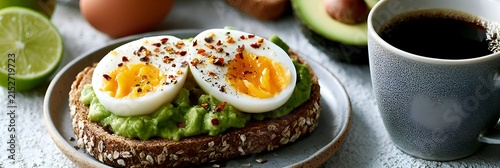 Healthy avocado toast with a soft-boiled egg, seasoned with chili flakes, served with coffee and lime