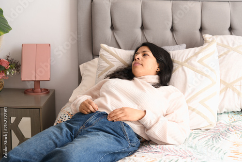 Quadro su tela Woman resting and thinking on bed in bedroom