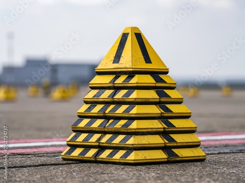Stack of aircraft wheel chocks ready for use on the apron at an airport with clear lighting conditions