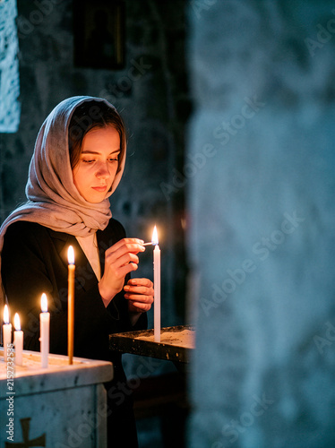 Woman lighting a candle in a church