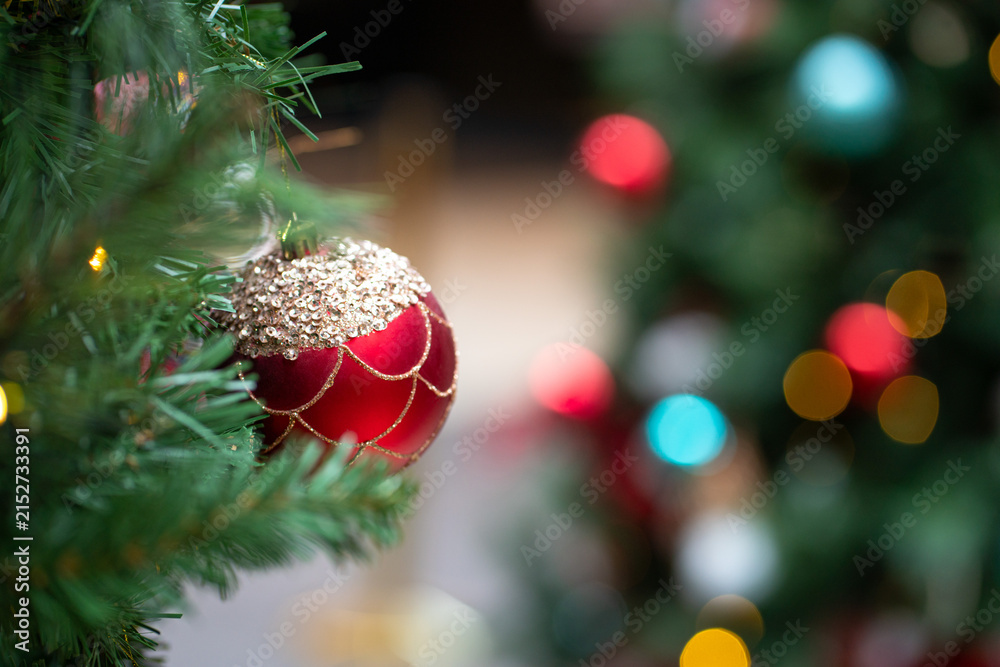 Obraz premium Christmas red round ball ornament hanging on tree. Holiday concept.