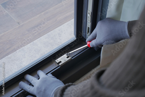 Fixing a window at home with a tool and gloves