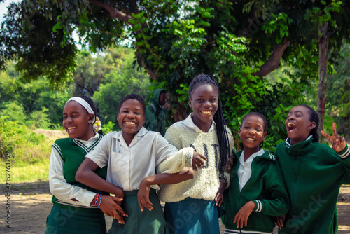 Happy African schoolchildren in uniforms enjoy a genuine moment of friendship and joy outdoors. A vibrant scene of education, unity, and shared learning, capturing the essence of daily school life.