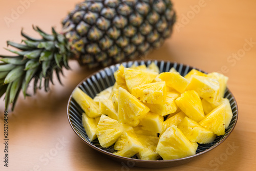 Whole pineapple and sliced pieces in plate