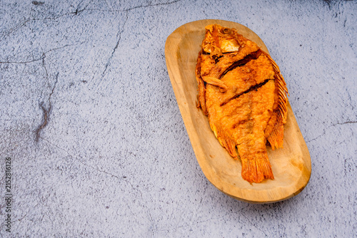 Delicious fried trout fish on a wooden plate