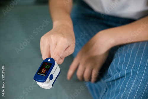 Obraz na plátne Young woman finger inserted into the pressure oximeter to assess health