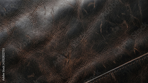 Dark brown distressed leather texture background with natural grain and vintage surface detail.