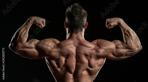 Flexing Biceps: A muscular man flexing his biceps, showcasing defined muscles and a powerful physique.