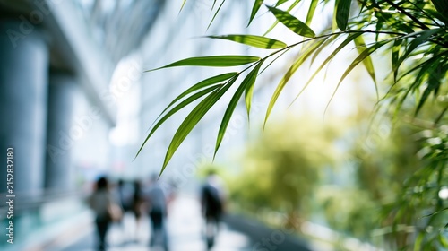 Lush green foliage frames a blurred indoor walkway with people.