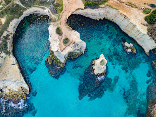 Aerial view of Beach Torre Sant'Andrea featuring dramatic limestone cliffs and turquoise sea Melendugno, Puglia, Italy.