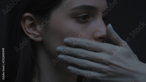Intimate Portrait of Woman Covered by Gloved Hand in Shadows