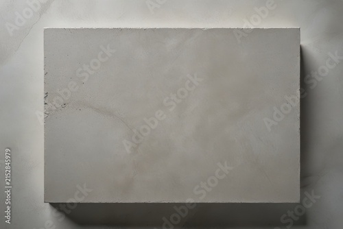 Minimalist close-up of light gray concrete block with smooth surface, subtle imperfections, and soft shadows, emphasizing clean geometric form and texture.
