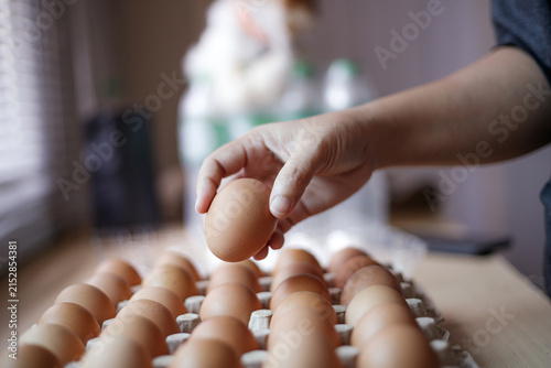 Hand Selecting Fresh Chicken Eggs from Egg Cartons