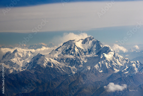 Aerial view of Nanga Parbat, the ninth highest mountain in the world, featuring snow-capped peaks, rugged ridges, and scattered clouds in the Himalayas, Gilgit-Baltistan, Pakistan.