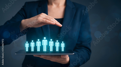 HR manager holding a tablet with glowing people icons, symbolizing recruitment, employee selection, and team leadership