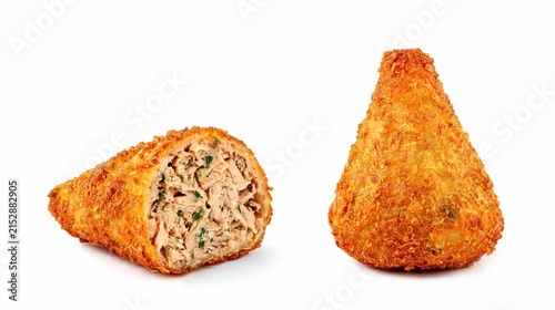 A crispy, deep-fried chicken coxinha sits on a black paper towel against a black background