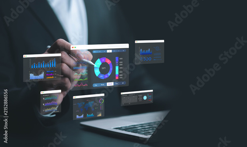 Business professional analyzing digital dashboards on a laptop, with interactive charts, metrics and reports visualizing data for business intelligence, performance tracking, planning and strategy.