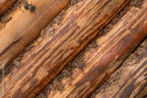 Wooden logs stacked in a row for construction. Large round logs. natural wooden background texture.