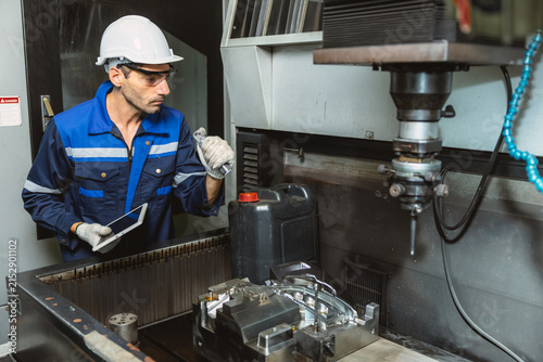 Obraz na płótnie Worker Operates EDM Machine inspecting Metal injection mold production in Thermoplastic Factory