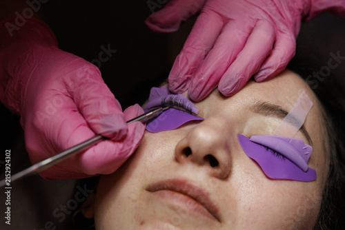 Fotografie Lashes are applied during a beauty treatment session in a salon while a client r