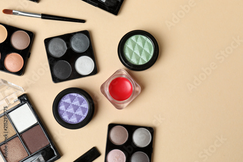 Fotografía Cosmetics and makeup brushes on a beige background, essential beauty and skincare products, flat lay composition