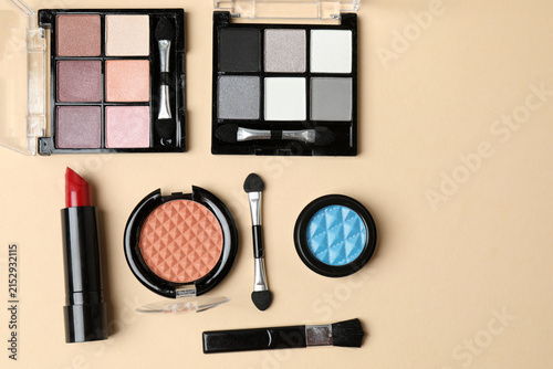 Fotografie Cosmetics and makeup brushes on a beige background, essential beauty and skincare products, flat lay composition