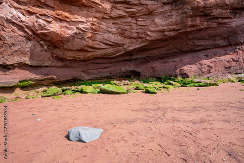 Coastal red rock formations and sand at low tide at Burncoat Head, Nova Scotia.