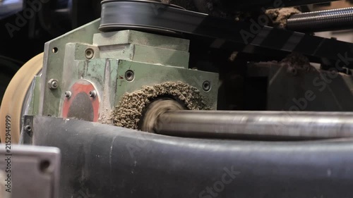 Heavy duty manufacturing machine component spinning with visible fiber buildup and pulp dust accumulation during corrugated board production.
