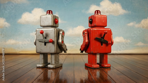 Vintage tin robot toys stand side by side on a polished wooden floor.