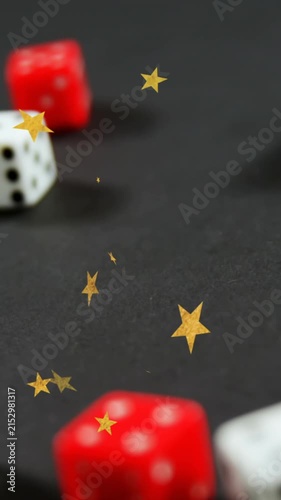 Animation of gold stars falling over white and red dice on grey background
