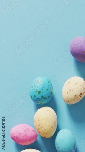 Animation of hand with easter decorations and easter eggs over blue background