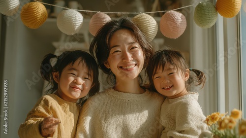 Joyful Asian woman with two children smiling indoors during celebration
