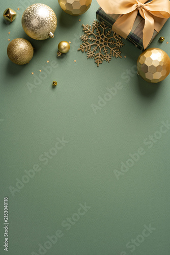 Christmas ornament vertical arrangement with golden baubles, wrapped gift and glitter snowflake for New Year