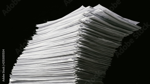 Large stack of paperwork symbolizes mental strain on workforce managing heavy workloads affecting mental health and productivity