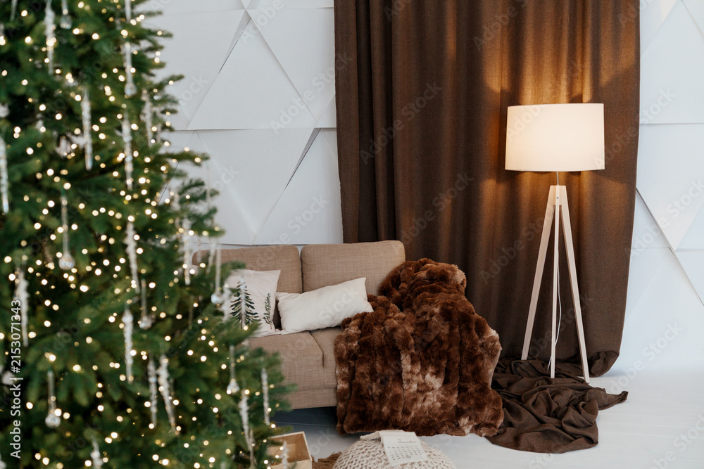 Fototapeta premium Cozy living room corner with Christmas tree and plush throw blanket next to sofa