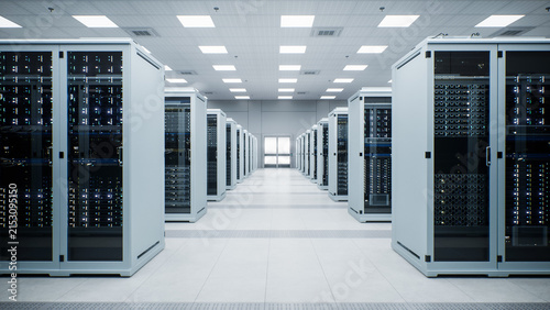 White Modern Data Center Server Room. Symmetrical Corridor View Down a Central Walkway Framed by Twin Rows of Enclosed Server Racks, Leading Toward Sealed Double Doors Beneath Ceiling Panel Lighting.