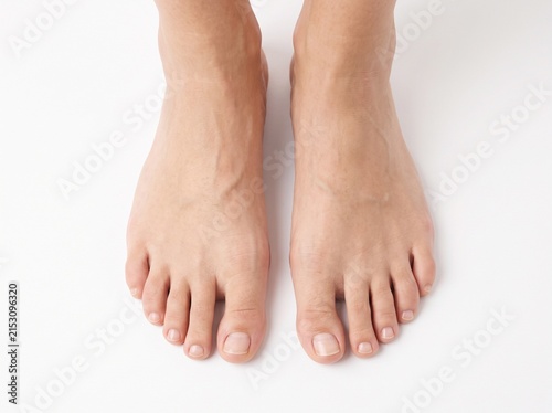 Young woman's beautiful bare feet and toes top view. Closeup isolated on white background.