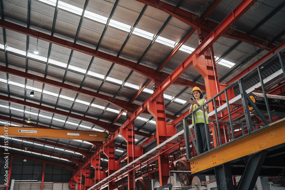 Fototapeta premium Technician Using Smartphone in Industrial Steel Manufacturing Plant